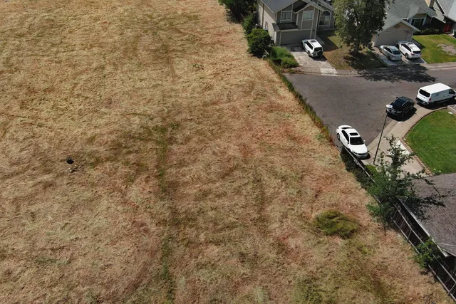 an aerial view of a house with a yard and trees all around