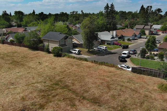 an aerial view of a house with a yard and trees