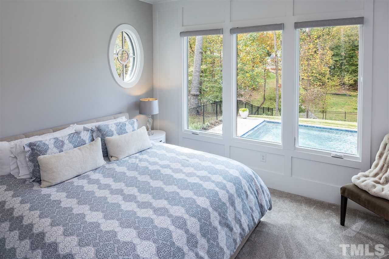 5417 Winding View Lane Raleigh, NC 27615 - Photo 18 of 30 The main level guest suite overlooks the breathtaking backyard and pool.