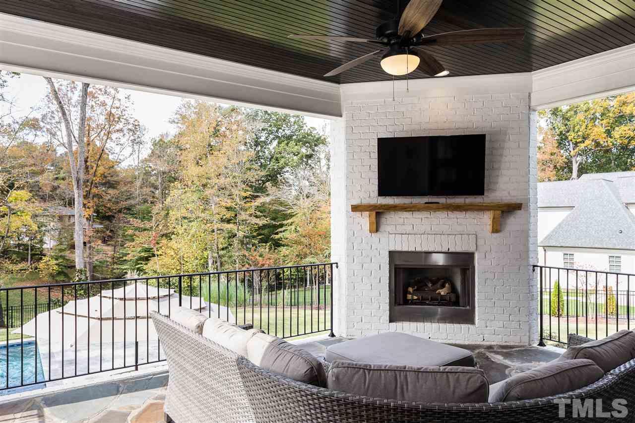 5417 Winding View Lane Raleigh, NC 27615 - Photo 28 of 30 Directly outside the great room is an expansive veranda with a gas fireplace overlooking the stunning salt water pool.
