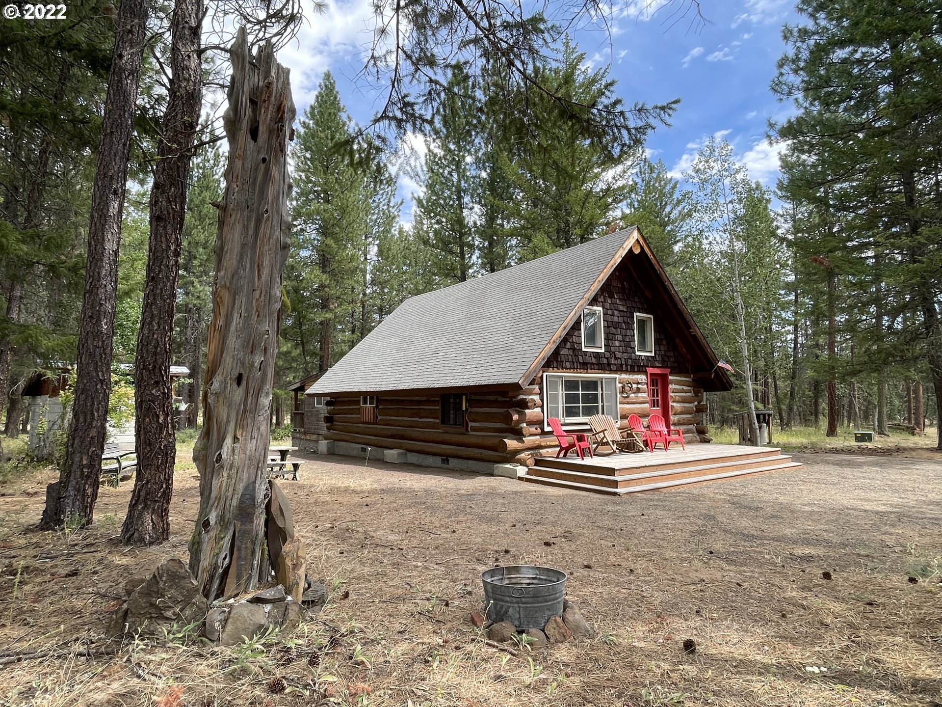 81 Soda Springs Road Goldendale, WA 98620 - Photo 2 of 31 a view of wooden house with a yard and large trees