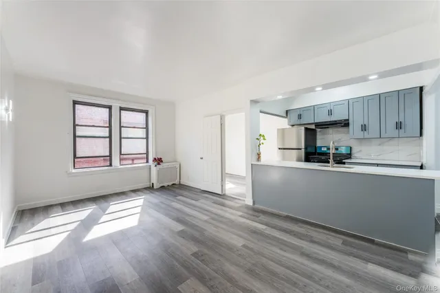 a kitchen with granite countertop white cabinets and wooden floor