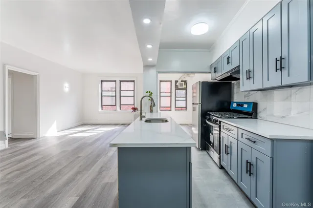 a kitchen with stainless steel appliances granite countertop a sink stove and wooden floor