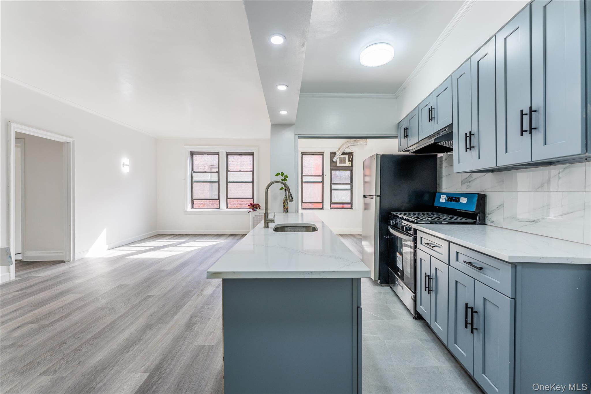 136-05 Sanford Avenue, Unit 6S Queens, NY 11355 - Photo 3 of 15 a kitchen with stainless steel appliances granite countertop a sink stove and wooden floor