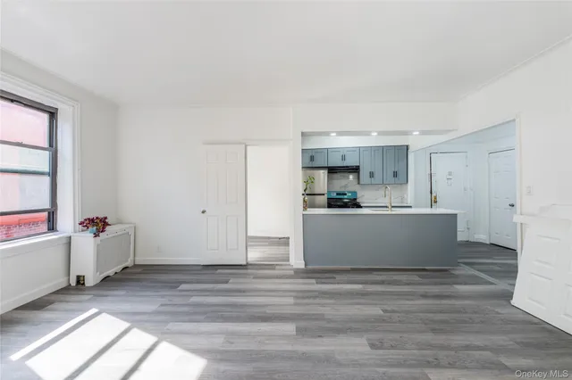 a view with kitchen island refrigerator sink microwave and cabinets