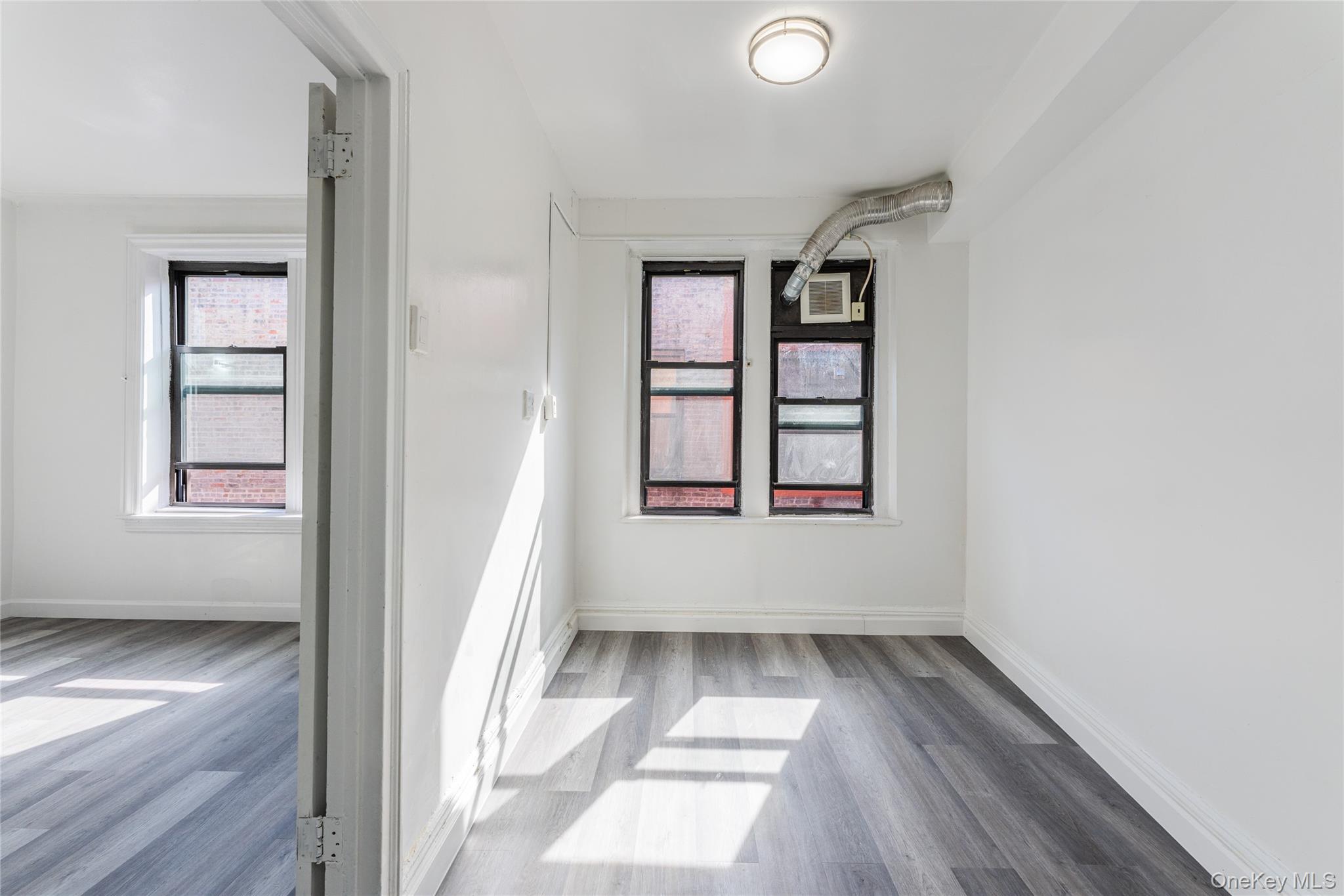 136-05 Sanford Avenue, Unit 6S Queens, NY 11355 - Photo 8 of 15 wooden floor in an empty room with a window