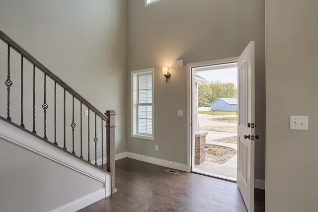 a view of a hallway with wooden floor and a living room