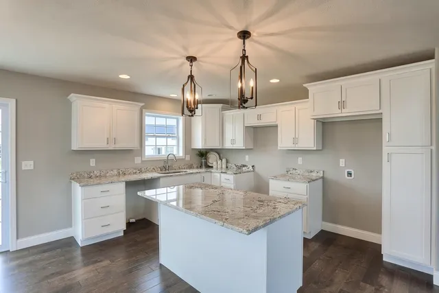 a kitchen with granite countertop white cabinets and a sink