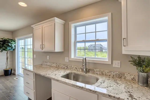 a kitchen with granite countertop a sink and a window