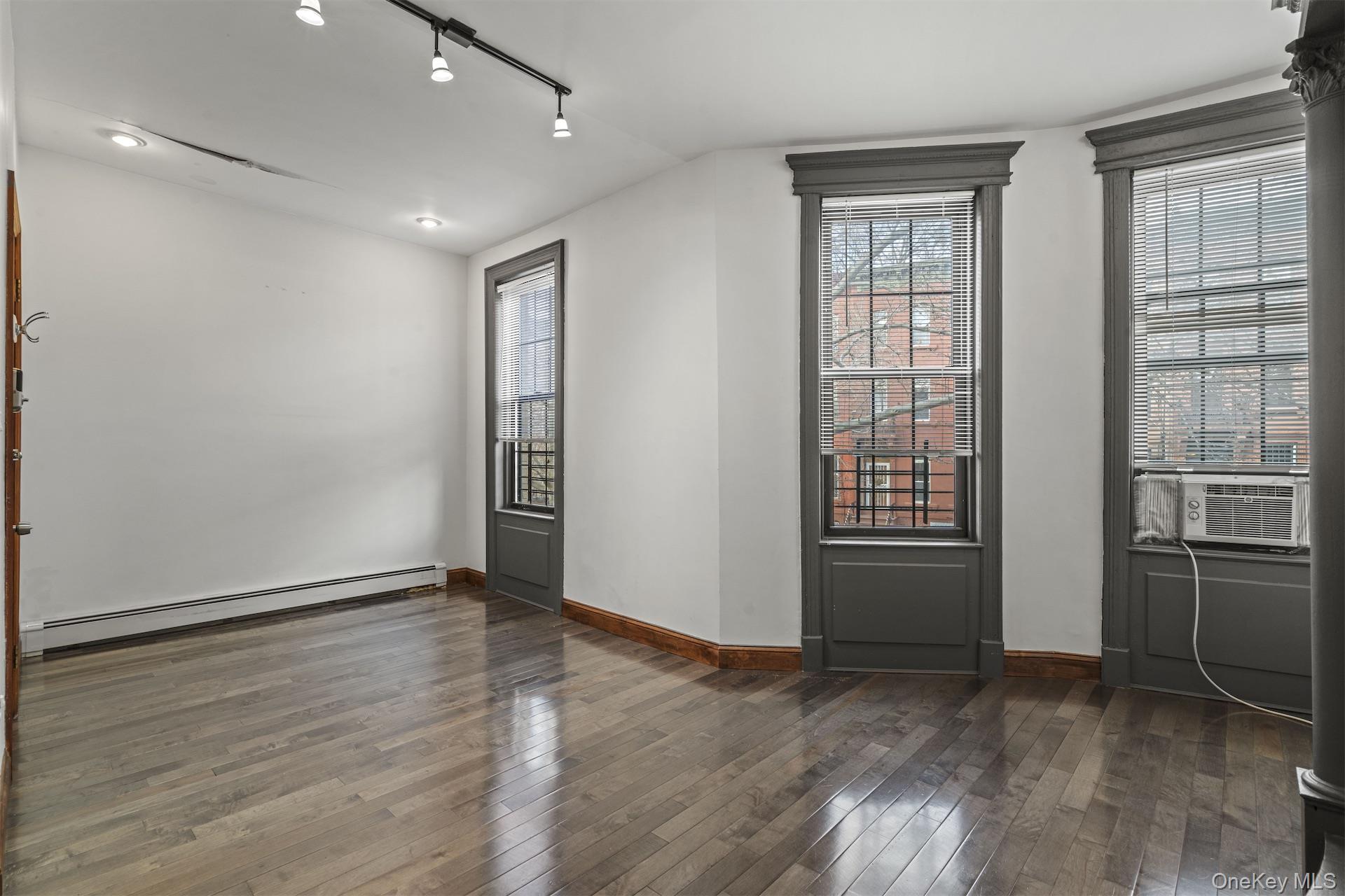 44 Decatur Street, Unit 2 Brooklyn, NY 11216 - Photo 2 of 8 an empty room with wooden floor and windows