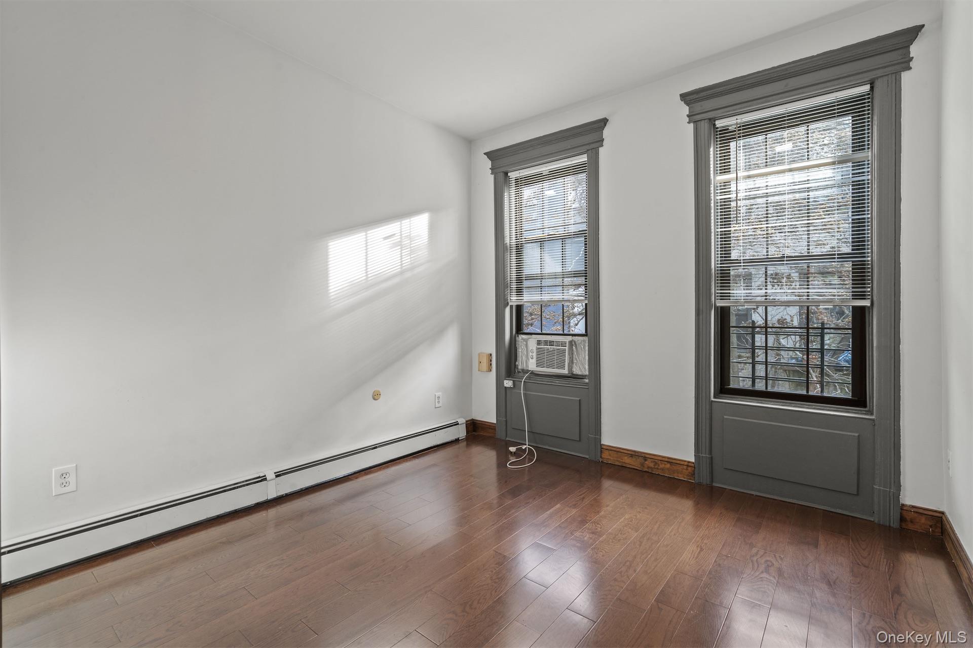 44 Decatur Street, Unit 2 Brooklyn, NY 11216 - Photo 3 of 8 an empty room with wooden floor and windows