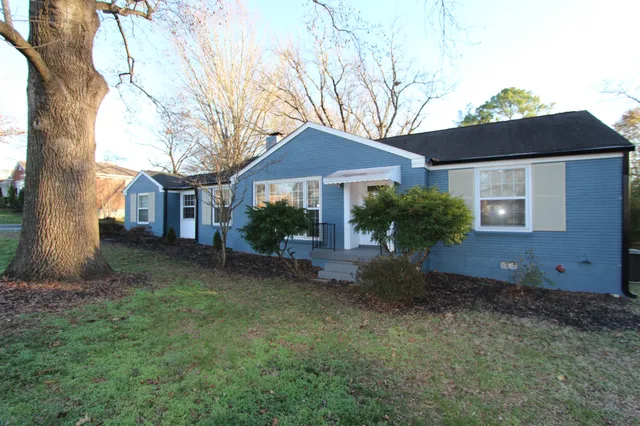 a view of a house with a yard and tree s