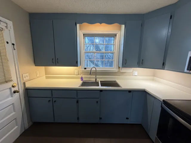 a kitchen with stainless steel appliances a refrigerator a sink a stove a microwave and island