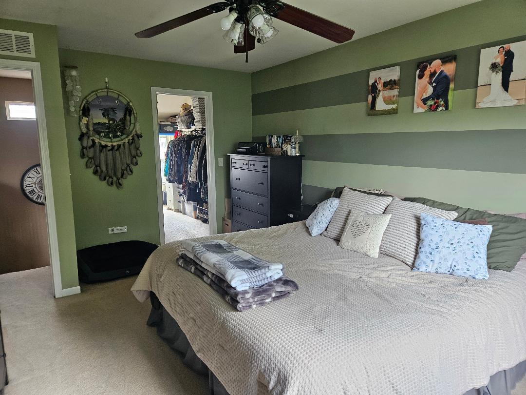 25159 Faraday Road Manhattan, IL 60442 - Photo 16 of 28 a bedroom with a bed and a chandelier