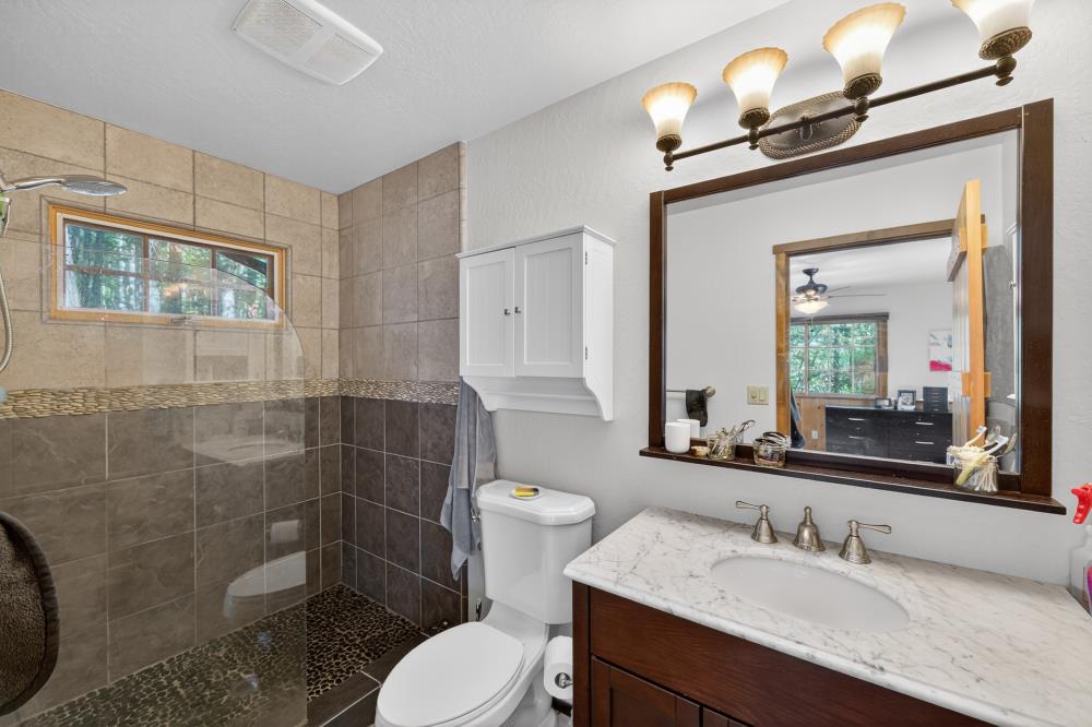 13052 Wood Rose Way Grass Valley, CA 95945 - Photo 25 of 46 a bathroom with a sink a toilet and a mirror