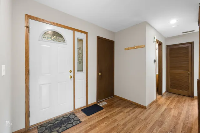 a view of a hallway with wooden floor and closet