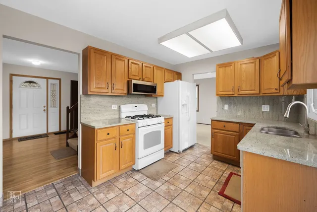 a kitchen with granite countertop cabinets stainless steel appliances a sink and a window