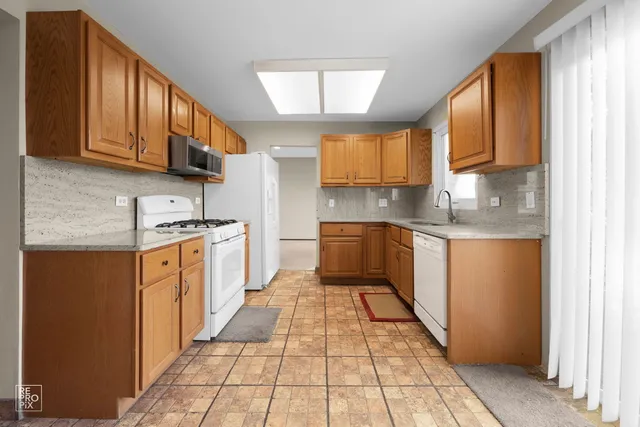 a kitchen with stainless steel appliances granite countertop a stove a sink and a refrigerator