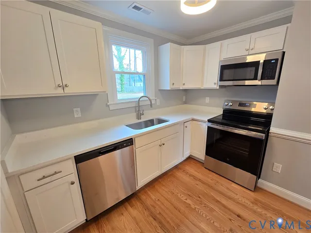 a kitchen with granite countertop white cabinets and black appliances