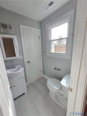 a bathroom with a toilet sink and a mirror