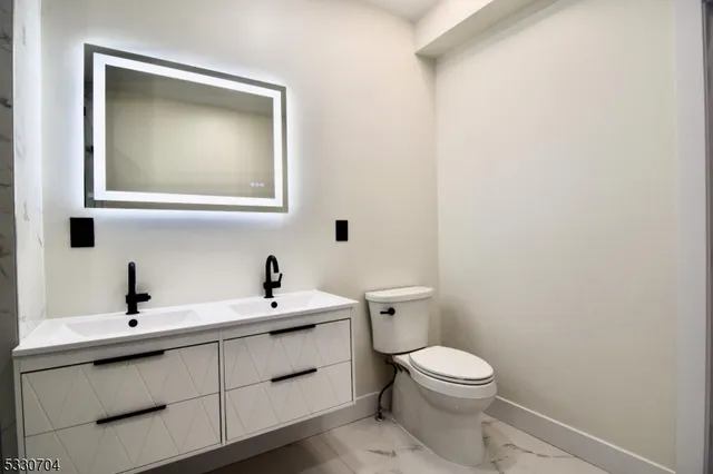 a bathroom with a toilet a sink and mirror