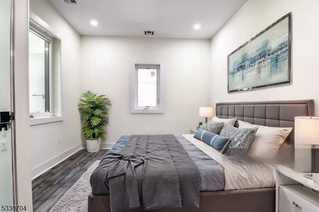 a bedroom with bed and a painting on the wall