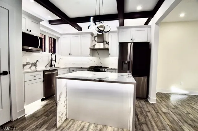 a kitchen with stainless steel appliances granite countertop a stove and a refrigerator