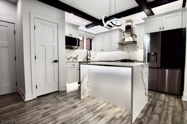 a kitchen with stainless steel appliances a refrigerator and a stove top oven