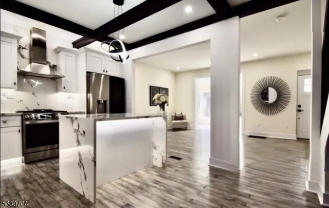 a kitchen with stainless steel appliances granite countertop a refrigerator and a stove