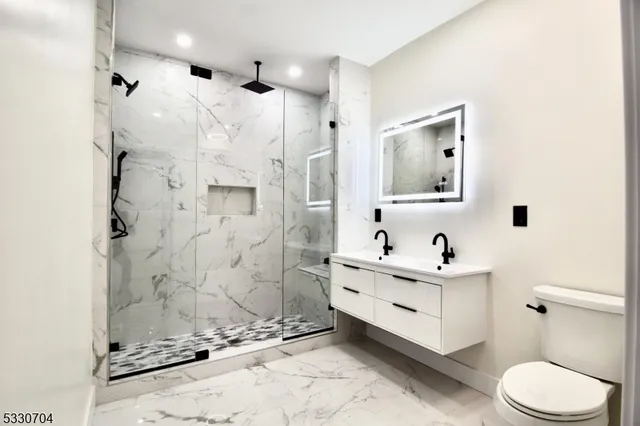 a bathroom with a sink a toilet and shower