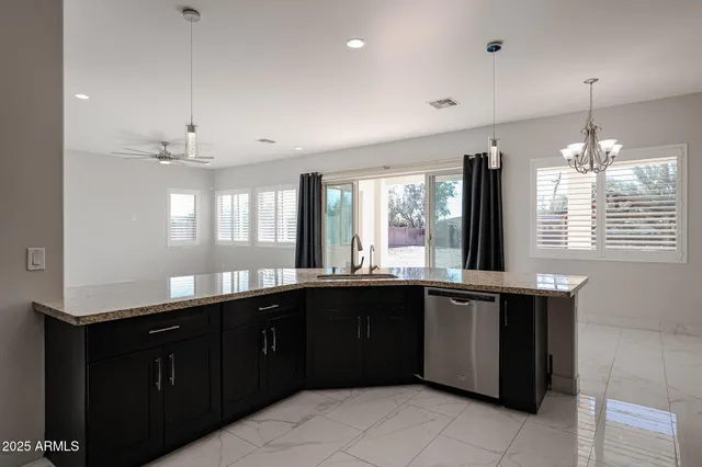 a large kitchen with granite countertop a stove sink and cabinets