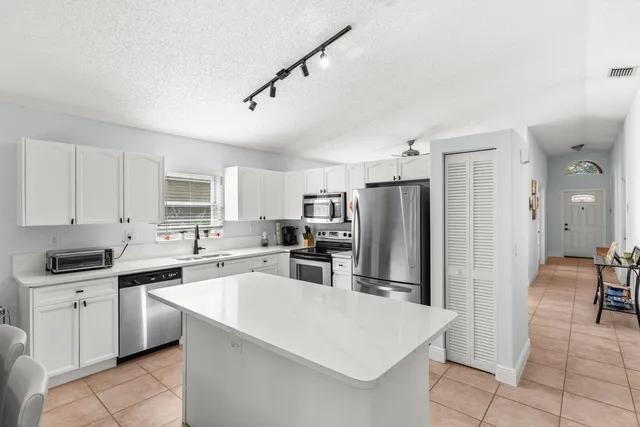 a kitchen that has a sink a counter top stainless steel appliances and cabinets