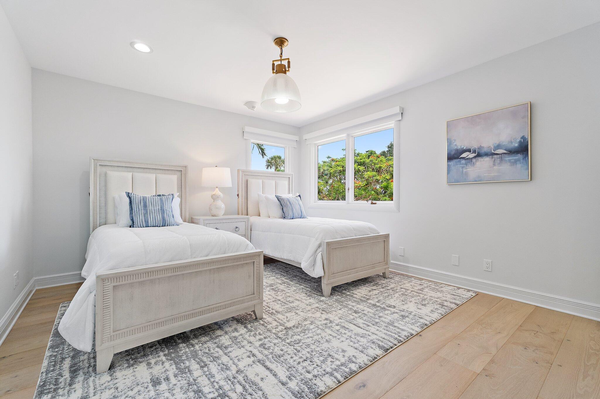 9 North River Road Stuart, FL 34996 - Photo 21 of 24 a spacious bedroom with two beds and a chandelier
