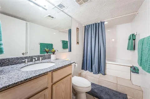 a bathroom with a granite countertop sink toilet and shower