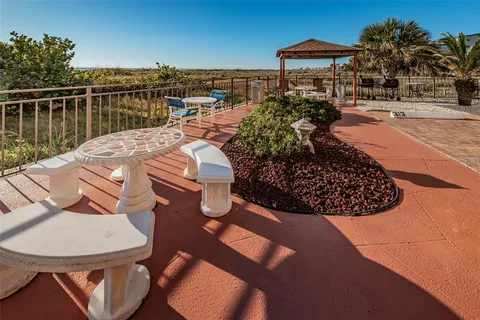 a view of a patio with a table and chairs under an umbrella