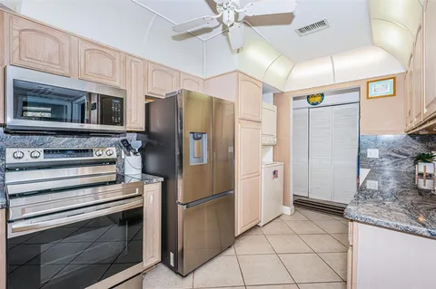 a kitchen with stainless steel appliances granite countertop a refrigerator and a stove top oven