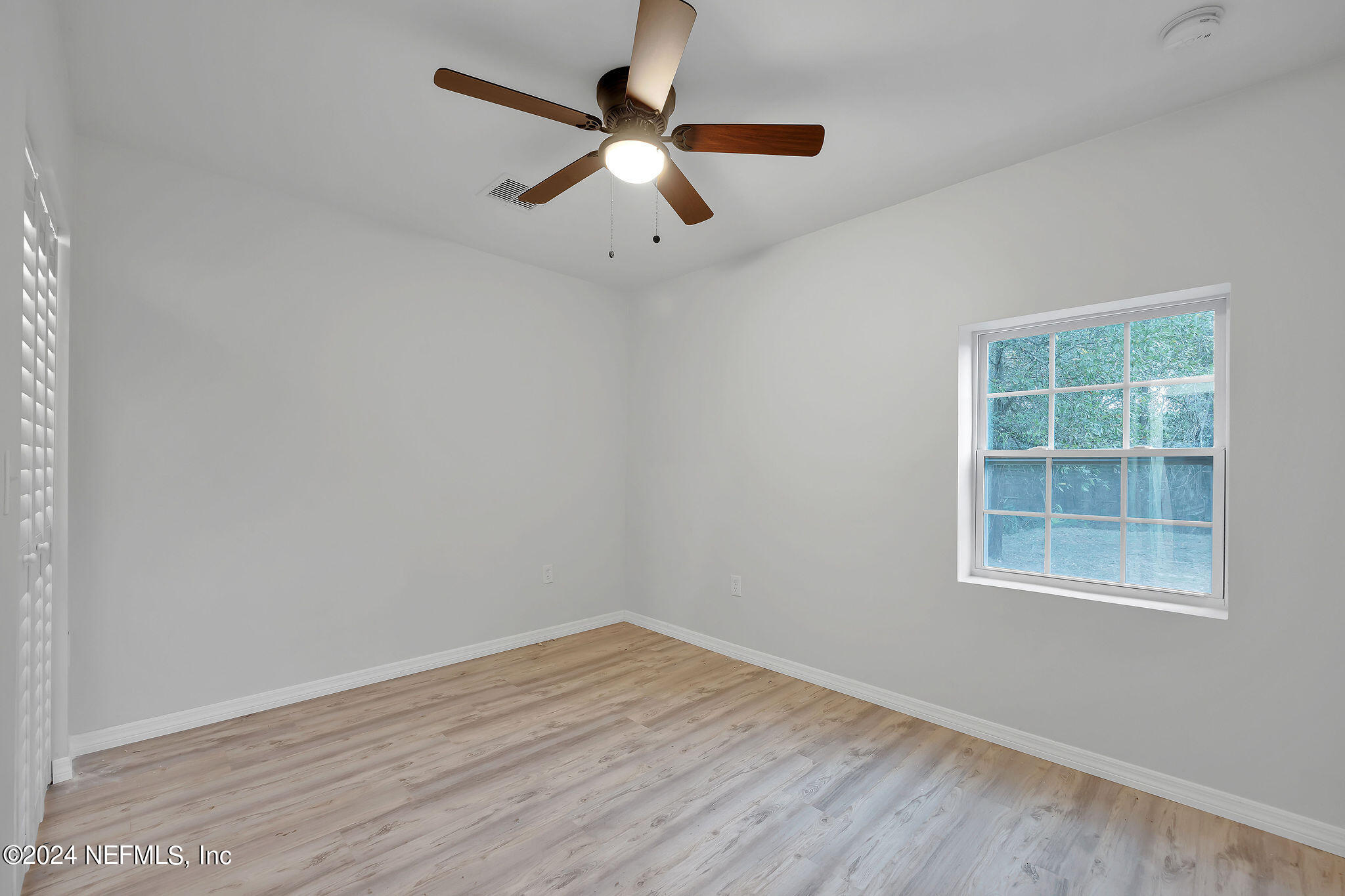 7519 Birdies Road Jacksonville, FL 32256 - Photo 14 of 24 an empty room with wooden floor ceiling fan and windows