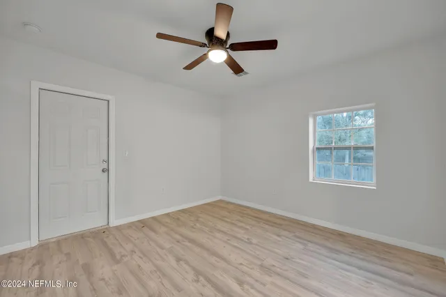 wooden floor in an empty room with a window