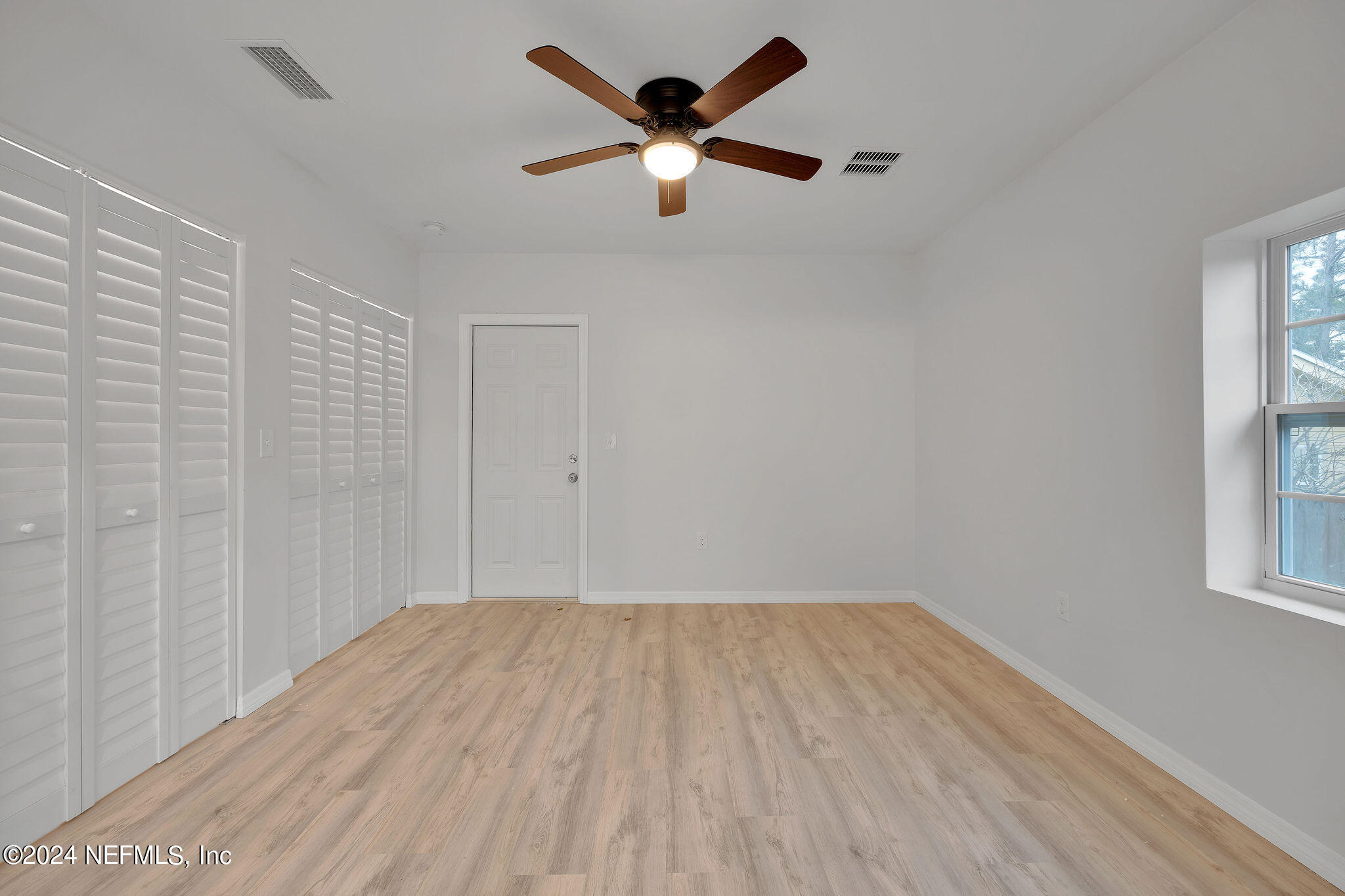 7519 Birdies Road Jacksonville, FL 32256 - Photo 19 of 24 an empty room with windows and fan