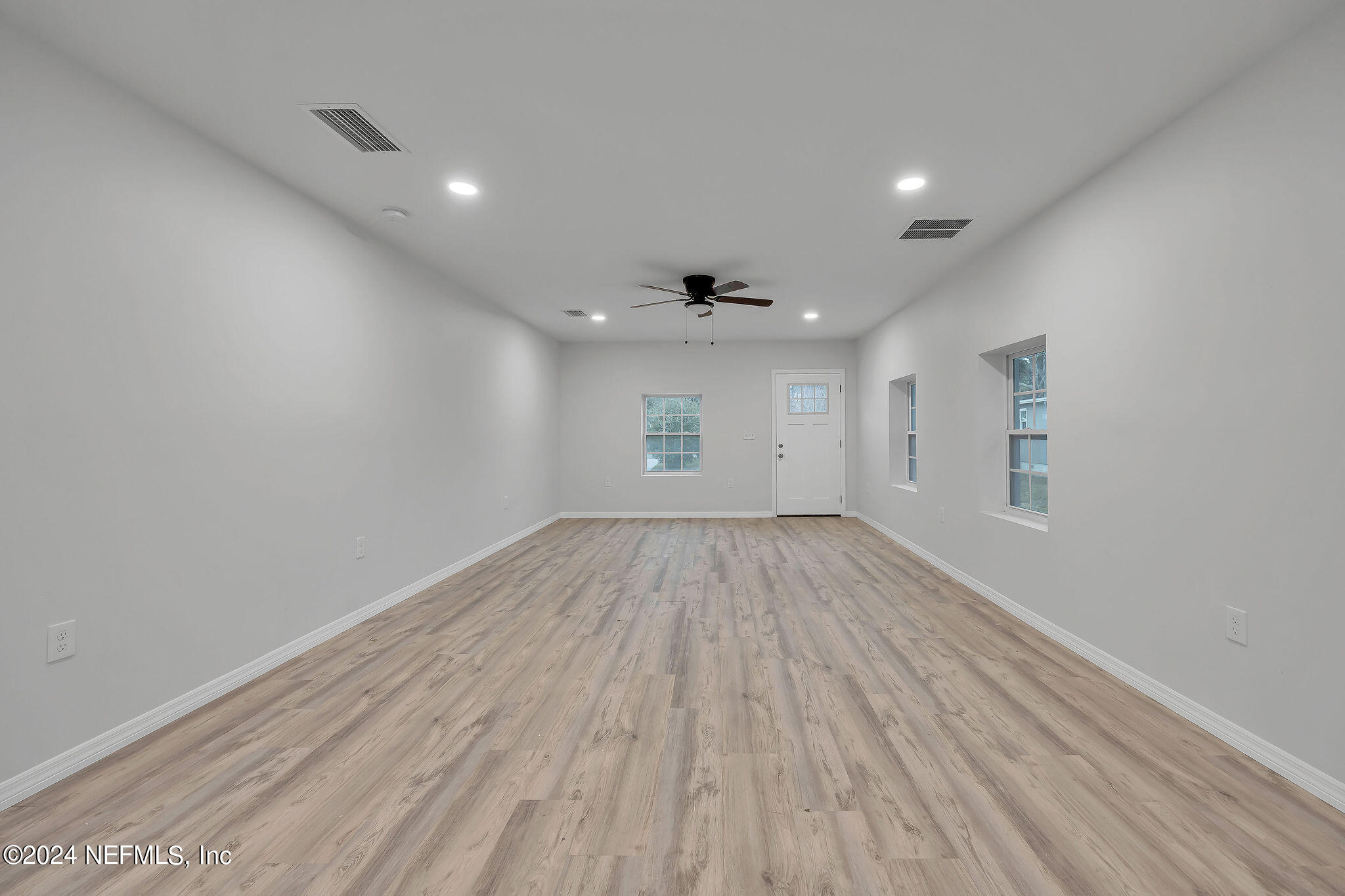 7519 Birdies Road Jacksonville, FL 32256 - Photo 6 of 24 an empty room with wooden floor and windows