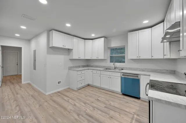 a kitchen with granite countertop white cabinets and white appliances