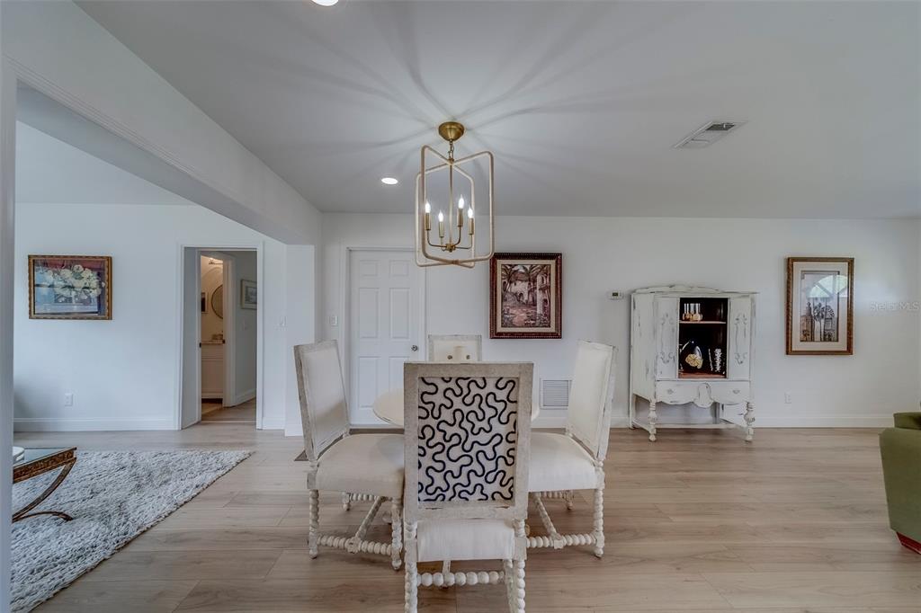 11424 79th Avenue Seminole, FL 33772 - Photo 11 of 62 a view of a dining room with furniture wooden floor and chandelier