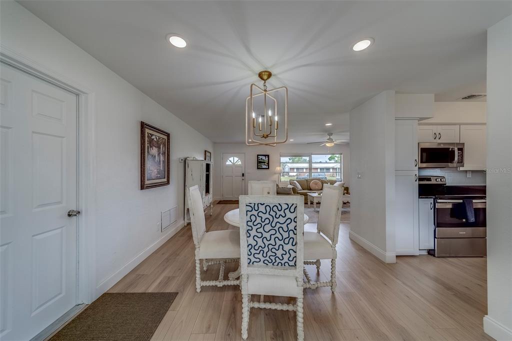 11424 79th Avenue Seminole, FL 33772 - Photo 12 of 62 a view of a dining room with furniture a chandelier and wooden floor