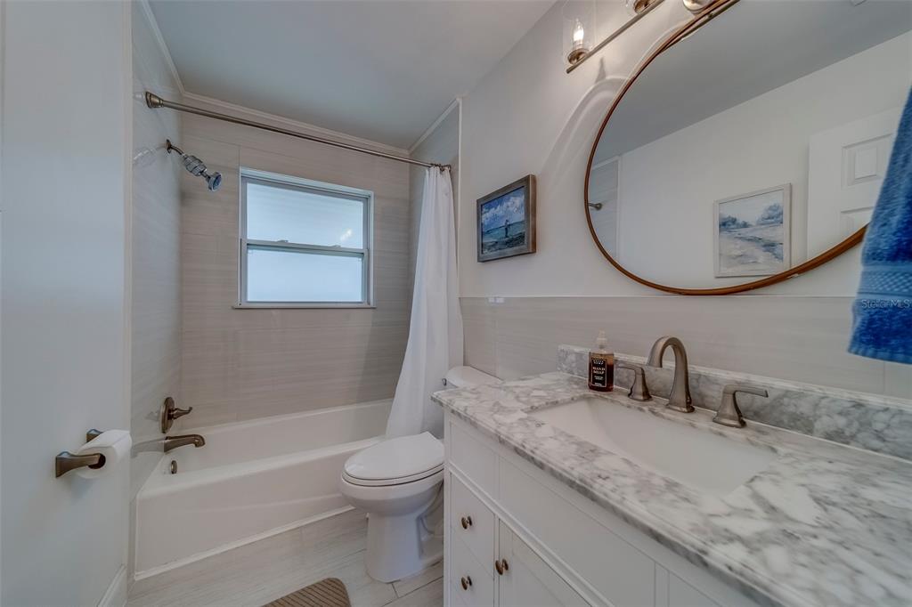11424 79th Avenue Seminole, FL 33772 - Photo 26 of 62 a bathroom with a granite countertop sink mirror vanity and toilet