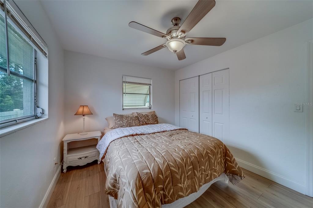 11424 79th Avenue Seminole, FL 33772 - Photo 30 of 62 a bedroom with a bed and a chandelier