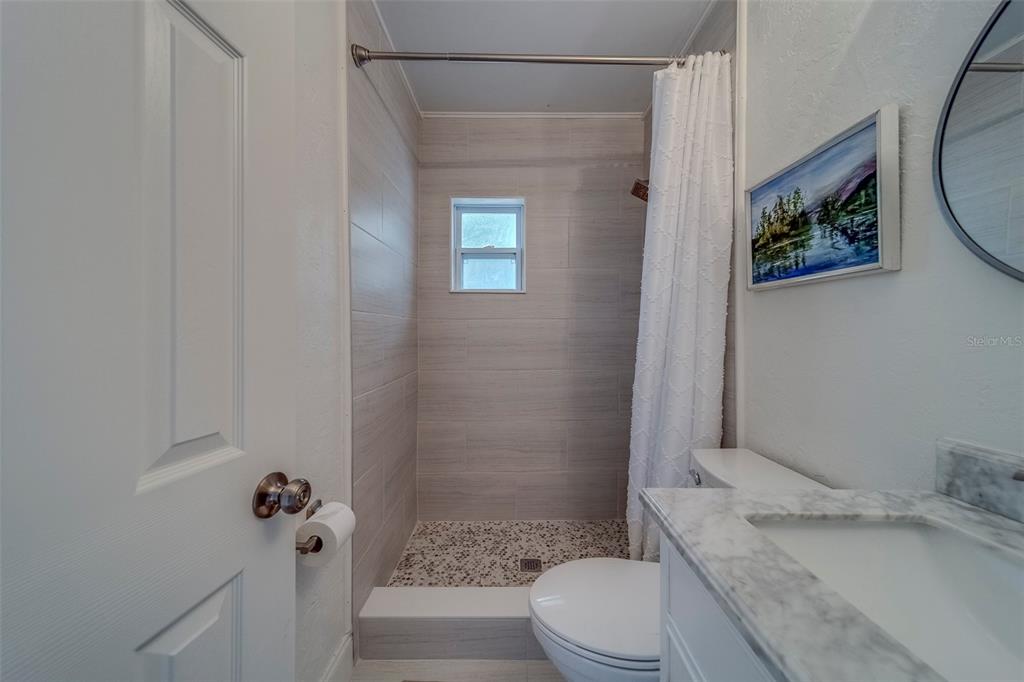 11424 79th Avenue Seminole, FL 33772 - Photo 34 of 62 a bathroom with a granite countertop sink toilet and shower