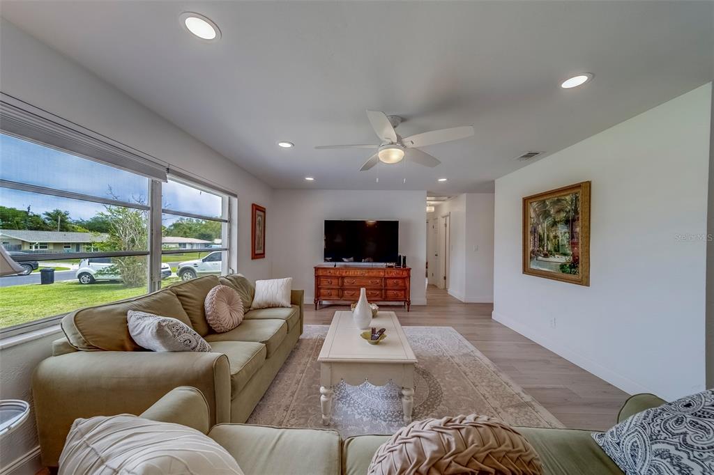 11424 79th Avenue Seminole, FL 33772 - Photo 9 of 62 a living room with furniture large window and a flat screen tv