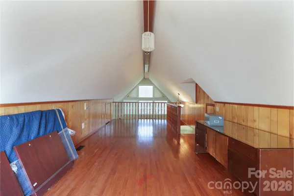a hallway with wooden floor table and chairs