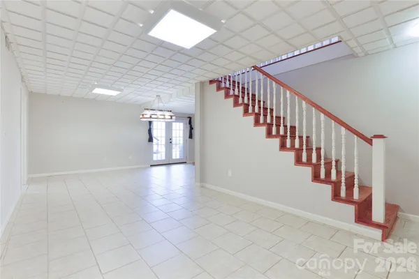 a hallway with wooden floor and staircase