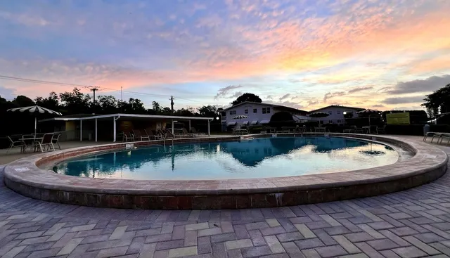 a front view of a house with a garden and trees